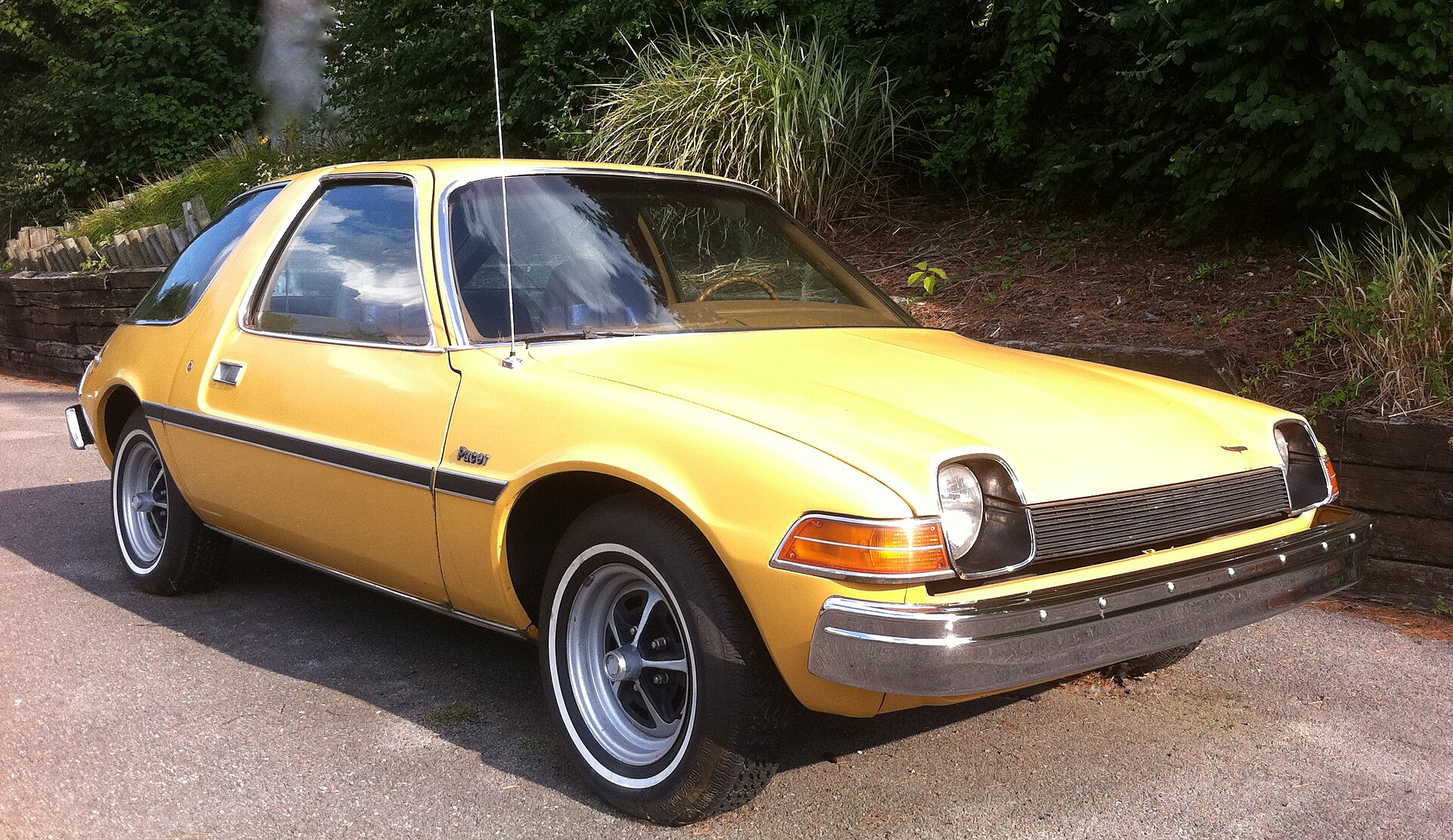 Light-coloured 1975 AMC Pacer with large glass area, front right view