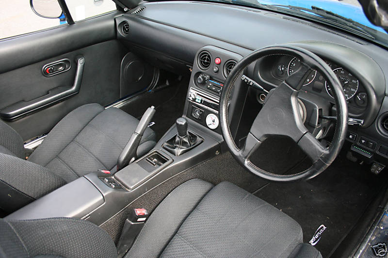 Black interior and steering wheel of a 1990 Mazda MX-5