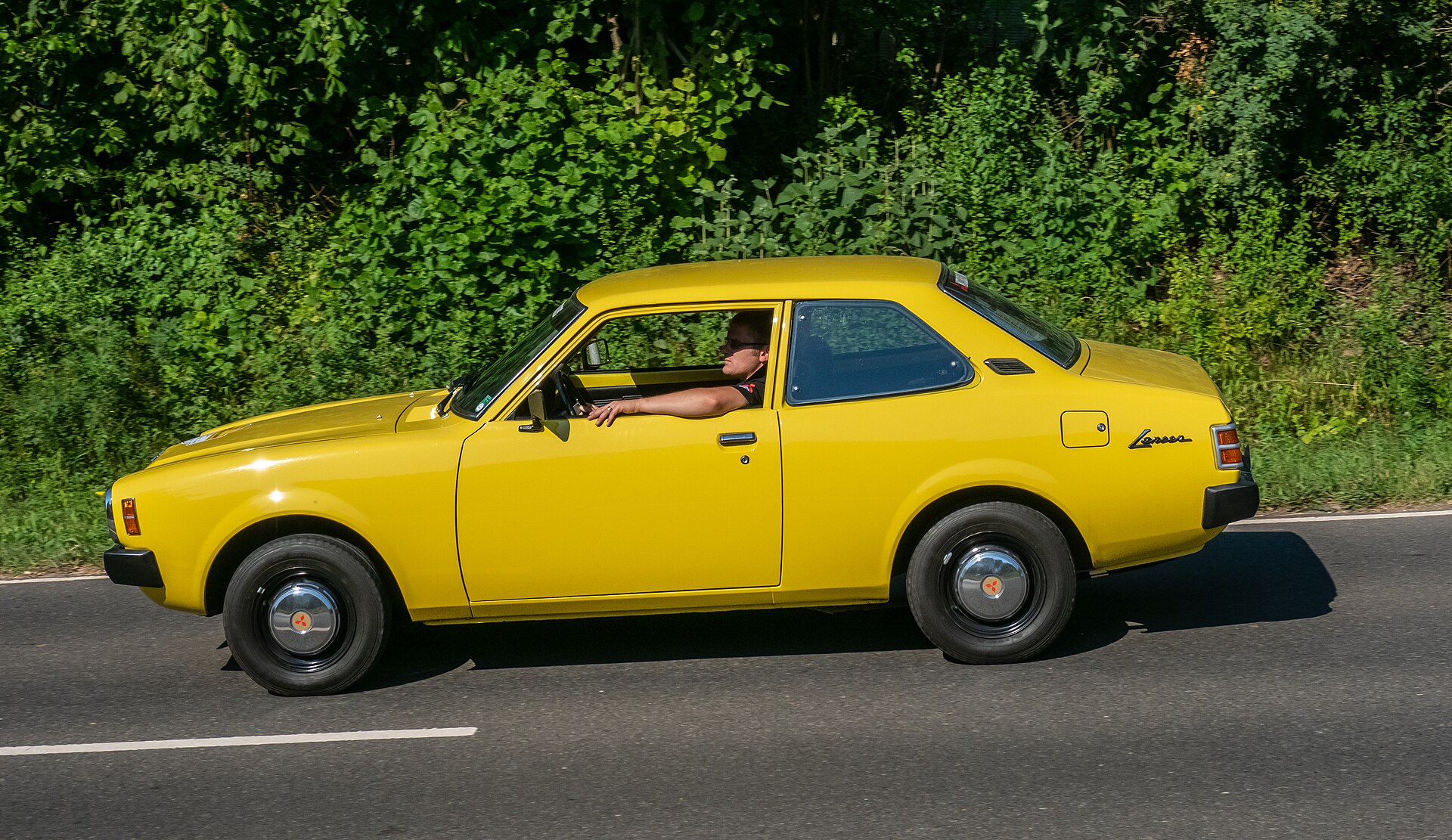 Classic first-generation Mitsubishi Lancer saloon on a rally
