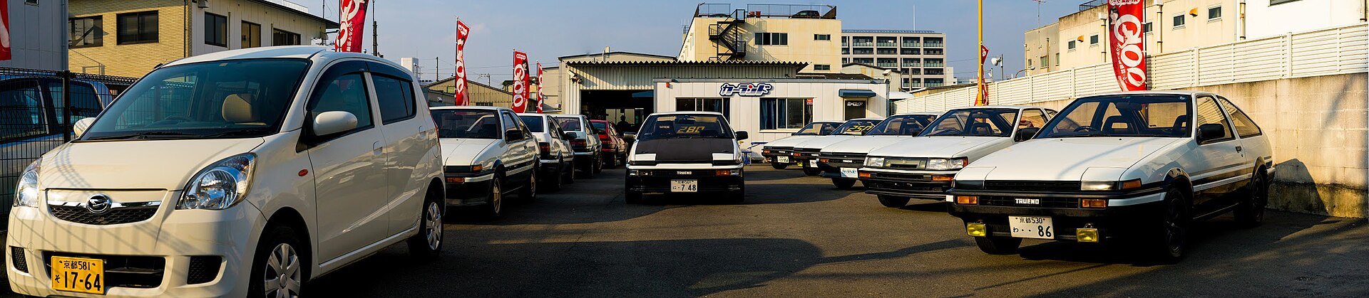 Several Toyota AE86 cars parked at a specialist dealer in Japan
